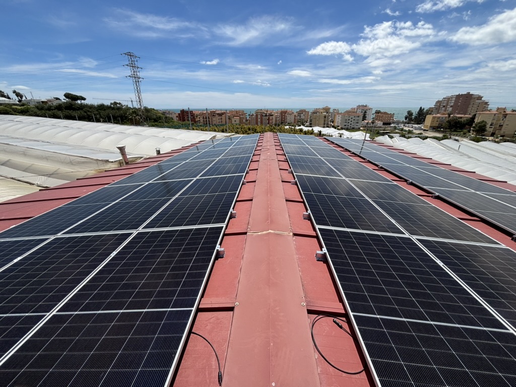 Solar installation on a warehouse roof with views over the Málaga coast